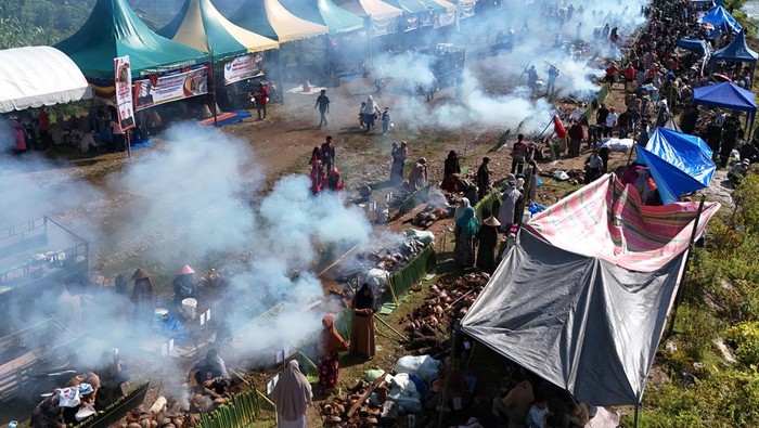 Peserta menuangkan santan ke dalam bambu saat proses memasak lemang (theut leumang) di bantaran sungai Desa Lhueng Asan, Aceh Barat Daya (Abdya), Aceh, Sabtu (25/4/2026). Kegiatan dengan memasak 15.000 batang lemang secara bersama-sama itu memecahkan rekor Museum Rekor Dunia Indonesia (MURI) dalam menyambut HUT ke-24 kabupaten setempat. ANTARA FOTO/Syifa Yulinnas/nym.