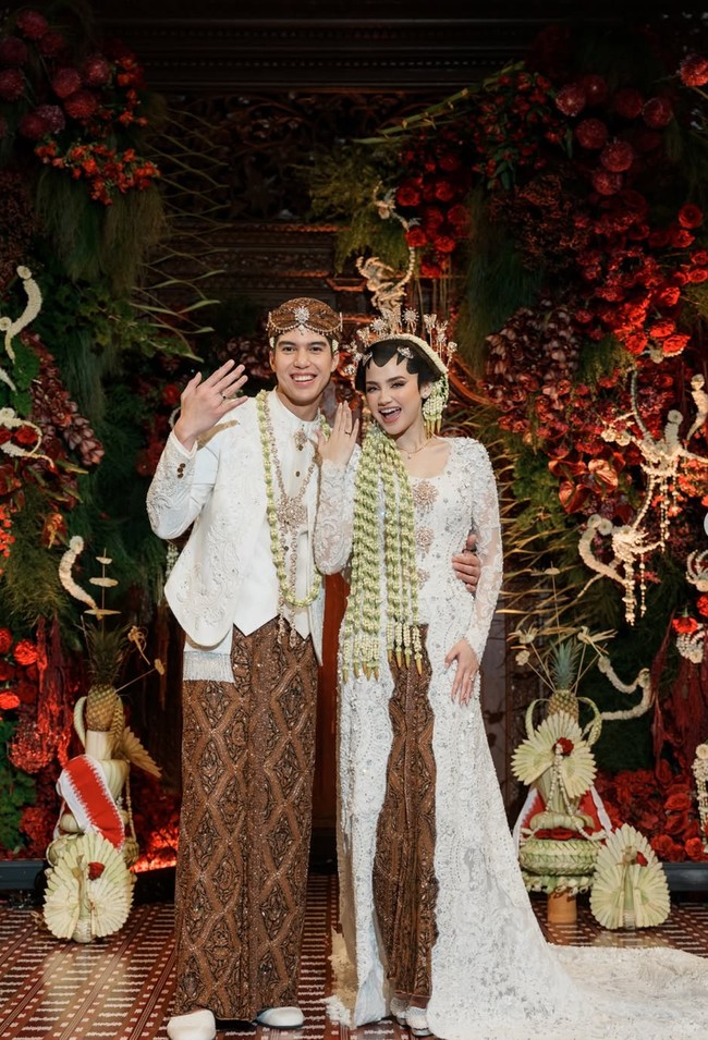 Rambut Syifa ditata dengan gaya sanggul paes, di mana bagian depan dibentuk dengan paes hitam khas Jawa yang melengkung tegas di dahi. Sanggulnya rapi dan rendah di belakang kepala, dihiasi melati yang menjuntai. Uniknya hiasan kepala cunduk mentul khas Jawa yang dikenakan Syifa tak hanya berbentuk bunga, melainkan juga kupu-kupu, gajah, hingga rusa. Foto: Instagram/@syifahadju
