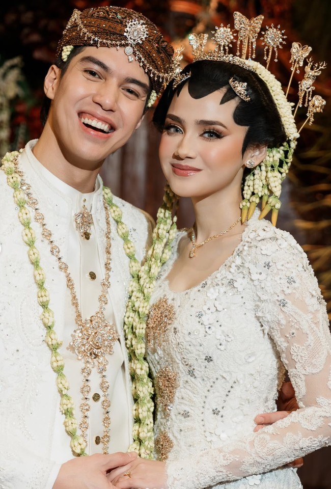 Untuk riasan wajahnya Syifa mempercayakan pada MUA ternama Bennu Sorumba. Mengusung makeup yang flawless dengan sentuhan soft glam, complexion-nya terlihat halus dan glowing, dipadukan dengan blush on bernuansa peach yang memberi efek segar. Riasan mata dibuat tegas dengan perpaduan eyeshadow cokelat dan bulu mata lentik yang mempertegas sorot matanya. Sementara itu, lipstik bernuansa pink nude membuat keseluruhan tampilannya terlihat manis, elegan, dan tidak berlebihan. Foto: Instagram/@syifahadju