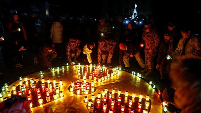 Warga Ukraina menggelar upacara peringatan 40 tahun tragedi Chernobyl Disaster dengan suasana khidmat di Slavutych, Minggu (26/4/2026). Peringatan tersebut diwarnai dengan aksi menyalakan lilin dan tabur bunga sebagai bentuk penghormatan kepada para korban yang meninggal akibat bencana nuklir terburuk dalam sejarah tersebut. REUTERS/Valentyn Ogirenko