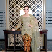 Foto ini menampilkan pose full-body Ashanty yang menonjolkan keindahan kebaya modifikasi dengan selendang tule transparan yang menjuntai. Kombinasi warna olive dan emas memberikan kesan mewah dan sophisticated. Dan aku suka karena ada hijaunya, ada tembaganya, terus warnanya itu kayak menampilkan warna baru yang aku belum pernah pakai juga gitu. Jadi aku suka warnanya, ucapnya. Foto: Dok. Instagram @ashanty_ash.