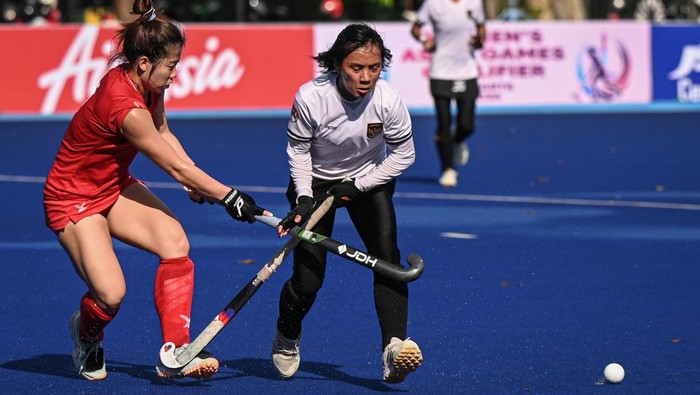 Pemain hoki putri Indonesia Maulani Salma (kiri) berusaha mengontrol bola melewati adangan pemain hoki putri Singapura Nadiah Ong (kanan) pada pertandingan kualifikasi Asian Games 2026 di Lapangan Hoki Gelora Bung Karno, Senayan, Jakarta, Minggu (26/4/2026). Tim hoki putri Indonesia menang dengan skor 2-0. ANTARA FOTO/Fauzan