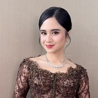 Riasan wajahnya yang flawless dan natural merupakan hasil tangan dari MUA Nooi Beauty. Complexion terlihat halus dengan hasil akhir glowing, dipadukan dengan blush on lembut yang memberi kesan segar. Riasan mata dibuat tegas namun tetap soft dengan bulu mata lentik dan eyeshadow bernuansa cokelat. Sementara itu, lipstik warna merah muda memberikan sentuhan manis yang menyempurnakan keseluruhan tampilan. Foto: Instagram/@nooibeauty