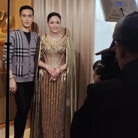 Di acara resepsi orangtua El dan Syifa kompak kenakan busana berwarna keemasan rancangan desainer Wiki Wu. Maia tampil glamor dengan gaun berwarna emas berpotongan leher v neck. Gaun tersebut dihiasi pola garis-garis vertikal dan lengkungan emas. Bagian lengannya memiliki potongan seperti jubah yang membuat penampilannya makin classy. Foto: Instagram/@wikiwu5