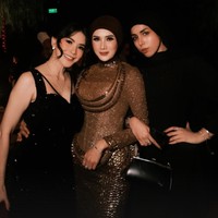 Sementara Mulan tampil dengan gaun bernuansa coklat dan emas dengan struktur yang unik. Terdapat detail kerah tinggi (high neck) dan aksen melingkar di area dada yang dilapisi payet emas. Bagian bawahnya tampak sangat struktural dengan tumpukan elemen dekoratif berbentuk studs emas yang memberikan kesan 3D yang megah. Foto: Instagram/@mulanjameela1