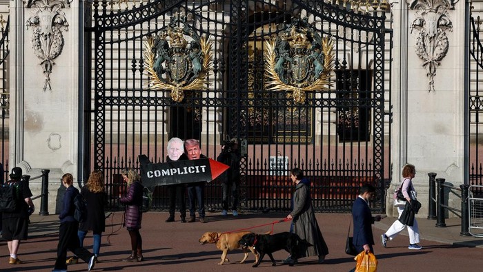 People from The Stop Trump Coalition dressed as Britain's King Charles and U.S. President Donald Trump hold a prop missile outside Buckingham Palace as the group opposes the bombing of Iran and calls on the UK to stop allowing use of UK military bases by U.S. aircraft, in London, Britain, April 27, 2026. REUTERS/Hannah McKay