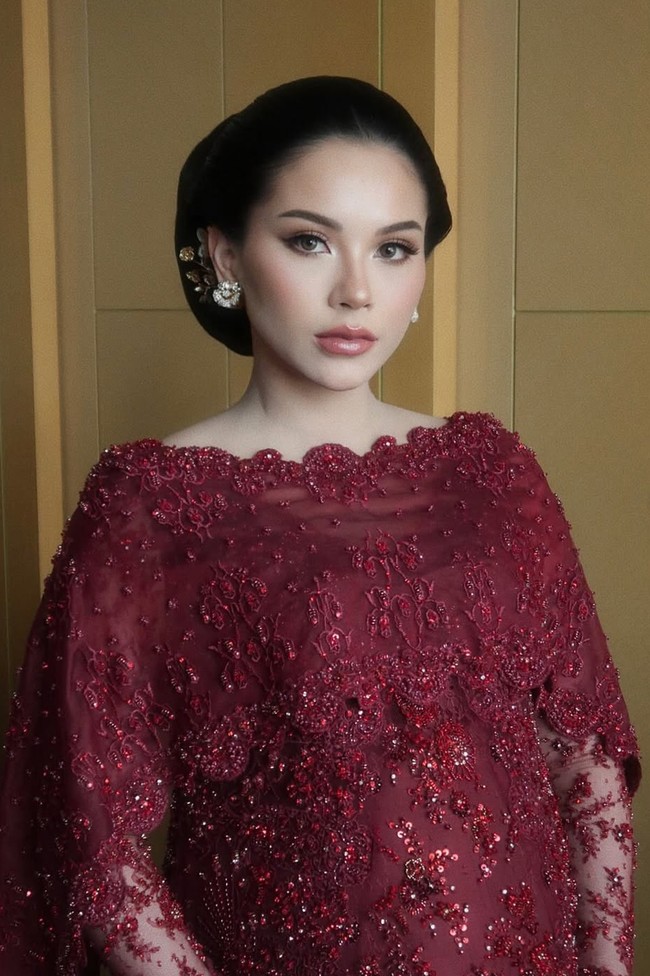 Serasi dengan busana yang dikenakan, Alyssa menata rambutnya dalam gaya sanggul klasik yang sleek dan rapi. Ia juga mempercantik bagian rambutnya dengan aksesori rambut bernuansa emas di sisi samping sanggul. Foto: Instagram/@rhay_david