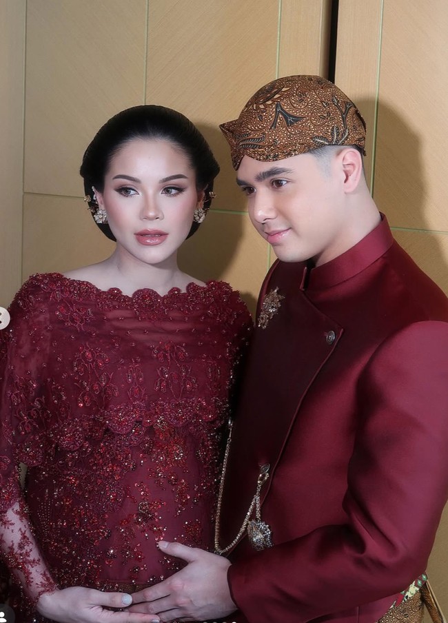 Alyssa tampil kompak dengan suaminya, Al Ghazali yang mengenakan busana senada. Al tampil kenakan beskap lengkap dengan blangkon di kepalanya. Foto: Instagram/@rhay_david