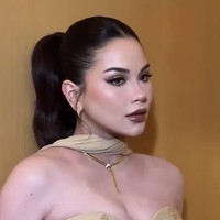 Bagian atas gaun didesain strapless sweetheart neckline yang dibalut layer transparan dengan aksen drapery di bahu, menciptakan efek off-shoulder yang anggun. Gaun tersebut juga dihiasi embellishment kecil berwarna senada yang tersebar, memberikan kilau tanpa terlihat berlebihan. Foto: Instagram/@rhay_david