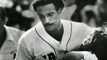 Pemain baseball Boston Red Sox, Jim Rice, menggendong seorang anak yang terluka akibat bola foul pada 1982. Aksinya disebut menyelamatkan nyawa sang bocah. Foto: Boredpanda