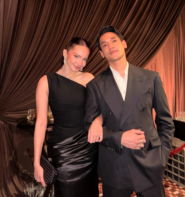 Enzy Storia memilih gaun simple dan elegan dengan potongan asimetris di bahu. Aktris sekaligus presenter ini juga menata rambutnya bergaya sleek minimalis, sementara riasan wajah bernuansa soft-nude. Foto: Instagram