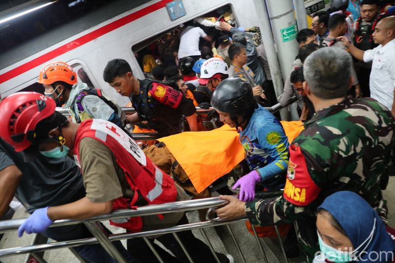 Petugas mengevakuasi korban kecelakaan kereta di Stasiun Bekasi Timur, Senin (27/4/2026). KRL Commuter Line ringsek dihantam rangkaian KA jarak jauh.