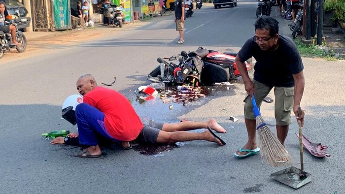 DA (31) kurir miras saat ditolong warga setelah kecelakaan di Simpang 4 MT Haryono, Kelurahan Kepatihan, Tulungagung