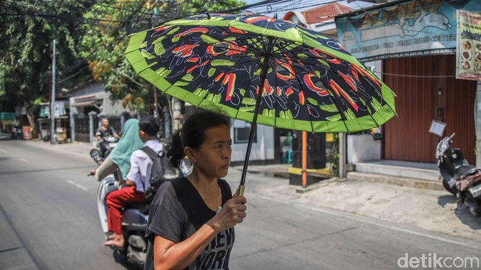 Sejumlah warga beraktivitas di tengah teriknya musim panas di kawasan Jakarta Utara, Senin (27/5/2026).