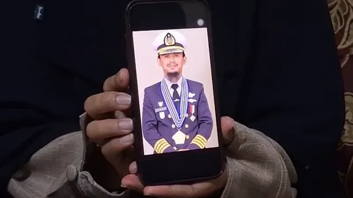 Santi Sanaya sedang menunjukkan foto suaminya, Ashari Samadikun yang saat ini sedang disandera bajak laut Somalia.