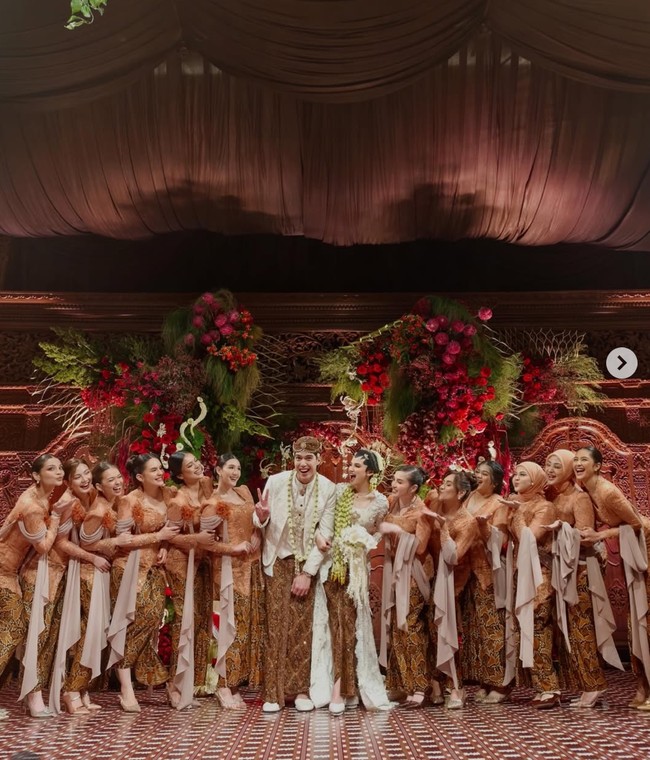 Kebaya dipadukan dengan kain batik bernuansa cokelat gelap dengan motif tradisional. Kombinasi ini menghadirkan kesan klasik khas Indonesia yang kuat. Foto: Instagram/@wirantikurniabride