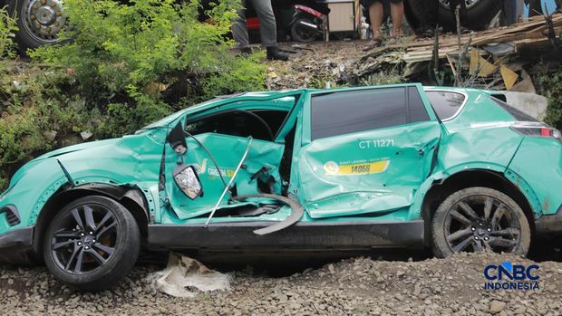 Kereta Krl melintas disamping taksi Green SM yang tertabrak KRL di perlintasan kereta Jalan Ampera, Bekasi, Selasa (28/4/2026). (CNBC Indonesia/Muhammad Sabki)