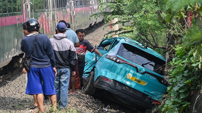 Warga mengamati taksi listrik Green SM  yang rusak pascakecelakaan dengan KRL Commuter Line dan KA Argo Bromo Anggrek di Bekasi Timur, Bekasi, Jawa Barat, Selasa (28/4/2026). Komite Nasional Keselamatan Transportasi (KNKT) mengerahkan tim investigasi untuk mengumpulkan fakta terkait kecelakaan kereta api di Stasiun Bekasi Timur pada Senin (27/4) malam. ANTARA FOTO/Fakhri Hermansyah/nz