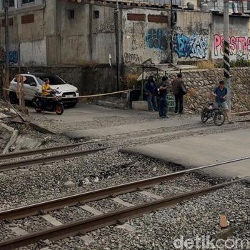 Perlintasan lokasi taksi tertemper KRL di Bekasi Timur hanya ditutup palang bambu. Perlintasan tak resmi tersebut dijaga warga secara bergantian. (Isal M/detikcom)