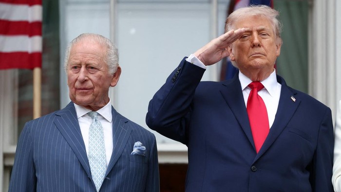 U.S. President Donald Trump salutes as he and Britains King Charles watch a pass in review from a balcony during an arrival ceremony for the king and Queen Camilla on the South Lawn of the White House, in Washington, D.C., U.S., April 28, 2026. REUTERS/Kevin Lamarque