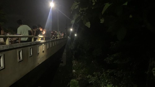 Warga mengerubungi sungai kawasan Perumahan Griya Menang Asri, Desa Kuripan, Kecamatan Kuripan, Lombok Barat, tempat remaja bernama Umbuh (13) hanyut, Selasa (28/4/2026) malam. (M. Zahiruddin/detikBali)
