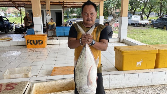 Wartono saat memegang ikan yang paling besar dari hasil tangkapannya