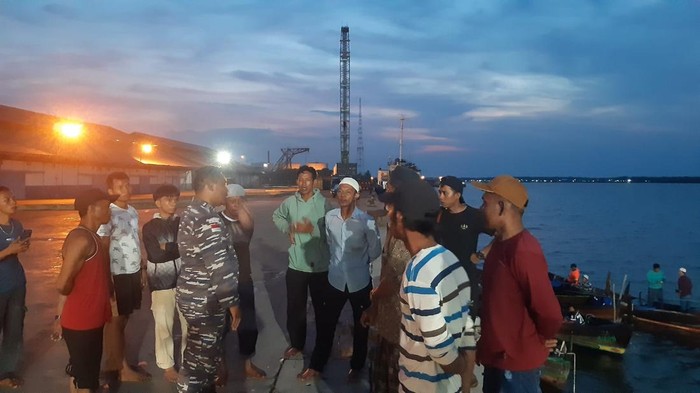 Warga bersama personel TNI AL saat mencari korban.