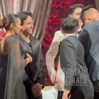 Sementara Zahwa tampil dengan dress bodycon dipadukan dengan cape berbahan organza yang menerawang. Penampilannya simpel dengan rambut sleek bun. Foto: YouTube/ AHMAD DHANI DALAM BERITA