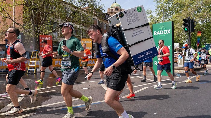 LONDON, UNITED KINGDOM - 2026/04/26: Jordan Adams is seen running the London Marathon with a 25kg fridge on his back to raise awareness for dementia as part of his personal challenge to take on 32 marathons in 32 days. The 2026 London Marathon featur