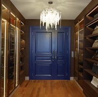 Walk-in closet langsung menyambut ketika pintu kamar utama dibuka. Kesan kontras tapi elegan terasa berkat kombinasi warna biru gelap pada pintu yang merupakan focal point, dan rak sepatu di sisi kiri dan kanan. (Foto: TikTok/@kiaisauraa)