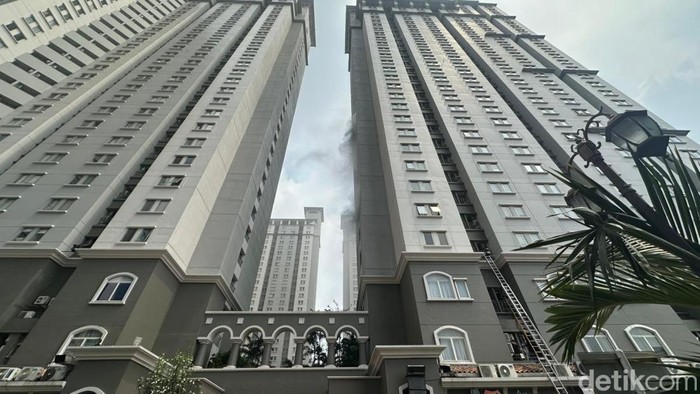Petugas damkar bersiaga di lokasi kebakaran Apartemen Mediterania, Tanjung Duren, Jakarta Barat (Jakbar). Asap hitam masih tampak mengepul. (Rizky/detikcom)