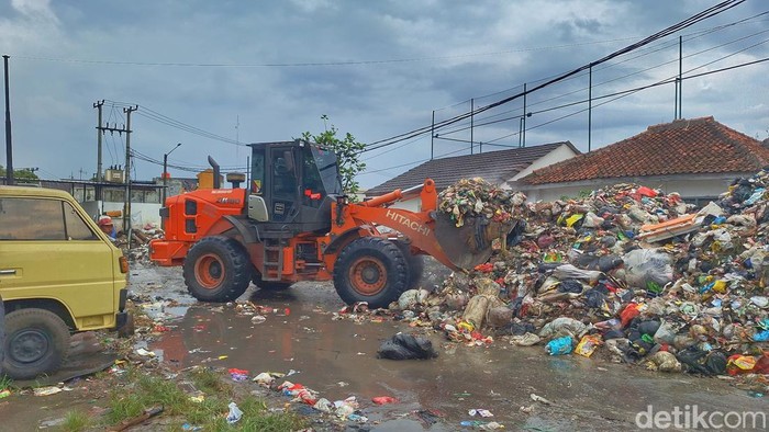 Petugas saat melakukan pembersihan sampah menggunakan alat berat di TPS Pasar Baleendah, Kabupaten Bandung, Kamis (30/4/2026).