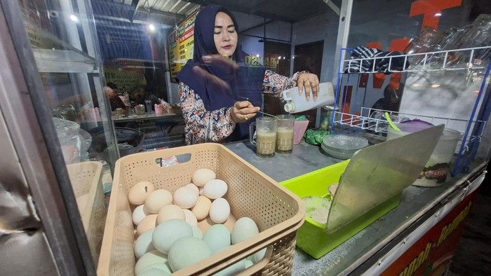 Ninik Mujiati saat meracik minuman STMJ di lapaknya Jalan Veteran Nganjuk
