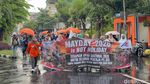 Potret Buruh di Surabaya Tetap Long March Meski Diguyur Hujan