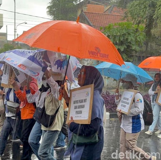 Potret Buruh di Surabaya Tetap Long March Meski Diguyur Hujan