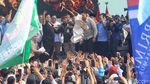 Momen Prabowo Subianto Buka dan Lempar Baju Safari ke Buruh di Monas
