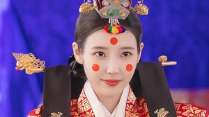Seong Hui Ju tampil dengan busana pernikahan tradisional berwarna merah dengan aksen emas. Tiga titik merah di wajah Hui Ju juga jadi elemen riasan yang gak kalah penting. (Foto: dok. MBC)