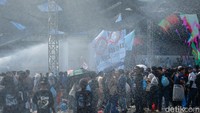 Sesekali air dari tim pemadam kebakaran menyemprotkan air untuk mendinginkan suasana. 