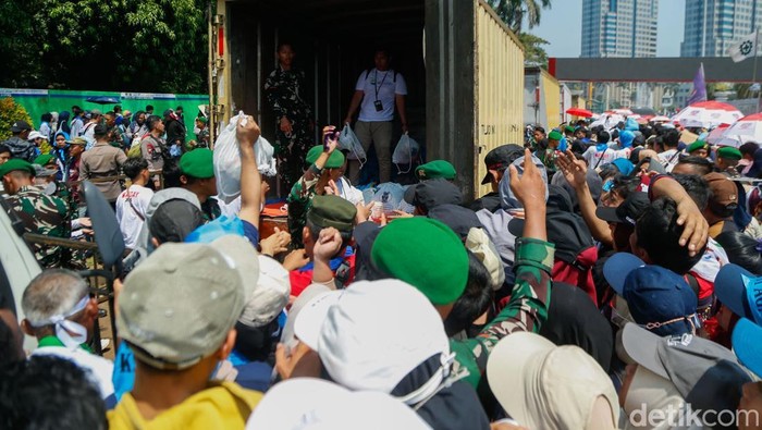 Buruh Berdesakan Saat Antre Sembako di Pintu Keluar Monas