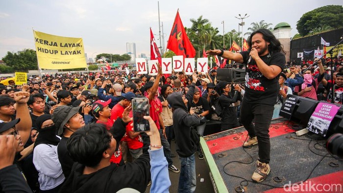 Sejumlah massa buruh memadati kawasan Gedung DPR RI dalam peringatan Hari Buruh Internasional atau May Day di Jakarta, Jumat (1/5/2026). Aksi tidak hanya diwarnai orasi dan tuntutan, tetapi juga hiburan musik yang menarik perhatian peserta.