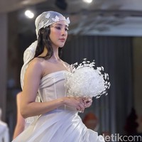 Ia melengkapi penampilannya dengan aksesori kepala transparan berhias bunga serta buket putih yang memperkuat nuansa bridal. (Foto: Daniel Ngantung/detikcom)