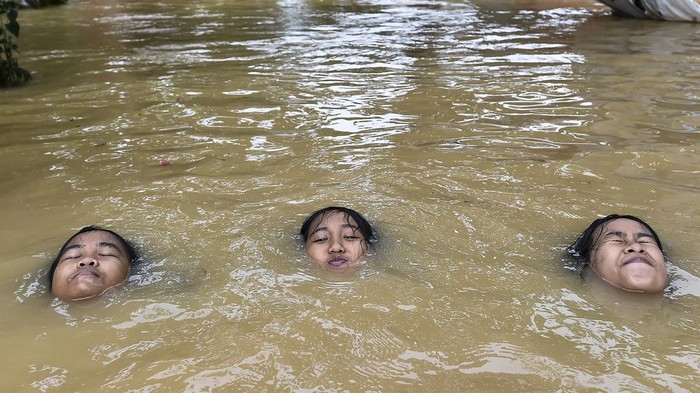 Tiga anak bermain air di jalan perumahan yang terendam banjir di Kenali Besar, Jambi, Sabtu (2/5/2026). Hujan deras sejak Sabtu (2/5) dini hari menyebabkan banjir setinggi 60-80 sentimeter yang merendam ratusan rumah di sejumlah kecamatan di Kota Jambi, antara lain Alam Barajo, Jelutung, dan Kota Baru. ANTARA FOTO/Wahdi Septiawan/tom.