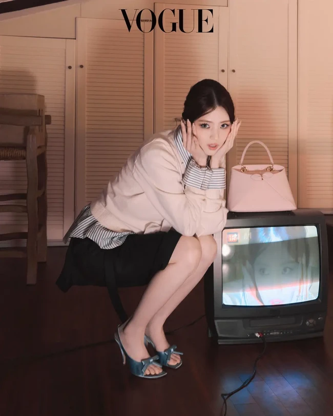 Super gemas! Han So Hee berpose imut ke kamera yang juga terlihat di layar TV antik. Koleksi tasnya Dior Cigale merupakan interpretasi dari garis-garis gaun sederhana yang dirancang Monsieur Dior pada 1952. Foto: dok. Vogue Korea