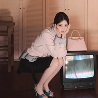 Super gemas! Han So Hee berpose imut ke kamera yang juga terlihat di layar TV antik. Koleksi tasnya Dior Cigale merupakan interpretasi dari garis-garis gaun sederhana yang dirancang Monsieur Dior pada 1952. Foto: dok. Vogue Korea