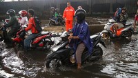Genangan air menutup sebagian badan jalan dan menghambat aktivitas lalu lintas warga.