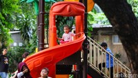 Anak-anak bermain di area perosotan. Ruang publik seperti Lapangan Banteng menjadi tempat yang mudah diakses bagi keluarga untuk menghabiskan waktu libur.