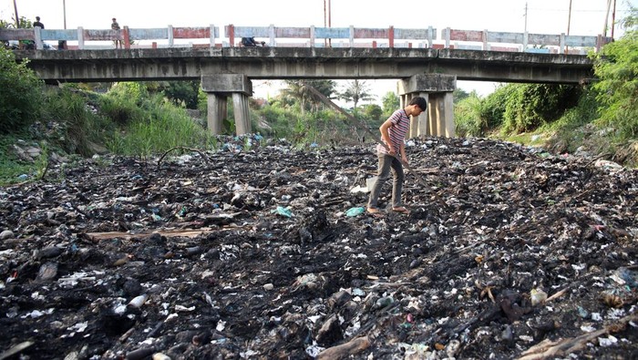 Warga berada di sungai yang dipenuhi limbah sampah di Desa Pematang Johar, Kecamatan Labuhan Deli, Kabupaten Deli Serdang, Sumatera Utara, Jumat (1/5/2026). Menurut warga, sungai tersebut tercemar limbah sampah rumahan dan limbah dari pabrik yang mengakibatkan bau tak sedap dan warna air sungai menjadi hitam. ANTARA FOTO/Yudi Manar/bar