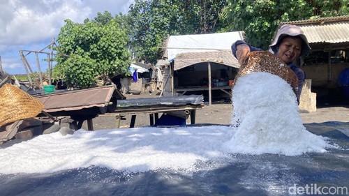 Ni Nyoman Sekar menjemur garam basah di tambak garam miliknya di Pantai Kusamba, Kecamatan Dawan, Klungkung, Bali, Minggu (3/5/2026). (Foto: Fatih Kudus Jaelani/detikBali)