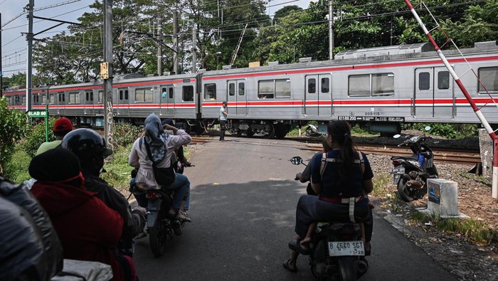 Sejumlah pengendara motor menunggu untuk menyeberangi jalur perlintasan kereta sebidang di kawasan Tanah Kusir, Kebayoran Lama, Jakarta, Minggu (3/5/2026). PT Kereta Api Indonesia (Persero) (KAI) mencatat sebanyak 130 perlintasan kereta sebidang belum dijaga dari total 423 titik perlintasan di wilayah Daop 1 Jakarta sehingga akan dilakukan penertiban bersama pemerintah daerah untuk meningkatkan keselamatan transportasi dan warga. ANTARA FOTO/Sulthony Hasanuddin/wsj.