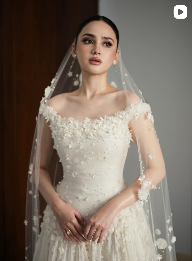 Syifa Hadju tampil anggun dan elegan dalam balutan gaun putih rancangan Hian Tjen. Bagian atas gaun memiliki potongan off-shoulder yang memperlihatkan bahu dan tulang selangka, memberi kesan anggun sekaligus romantis. Foto: Instagram/@hiantjen